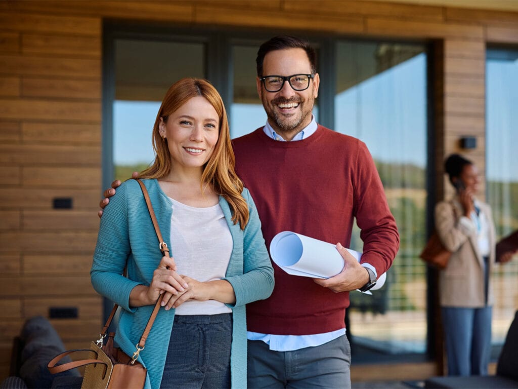 Couple holding the plans for their future home