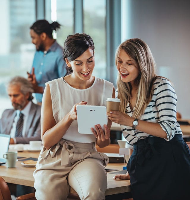 Deux investisseuses consultent un projet immobilier sur une tablette